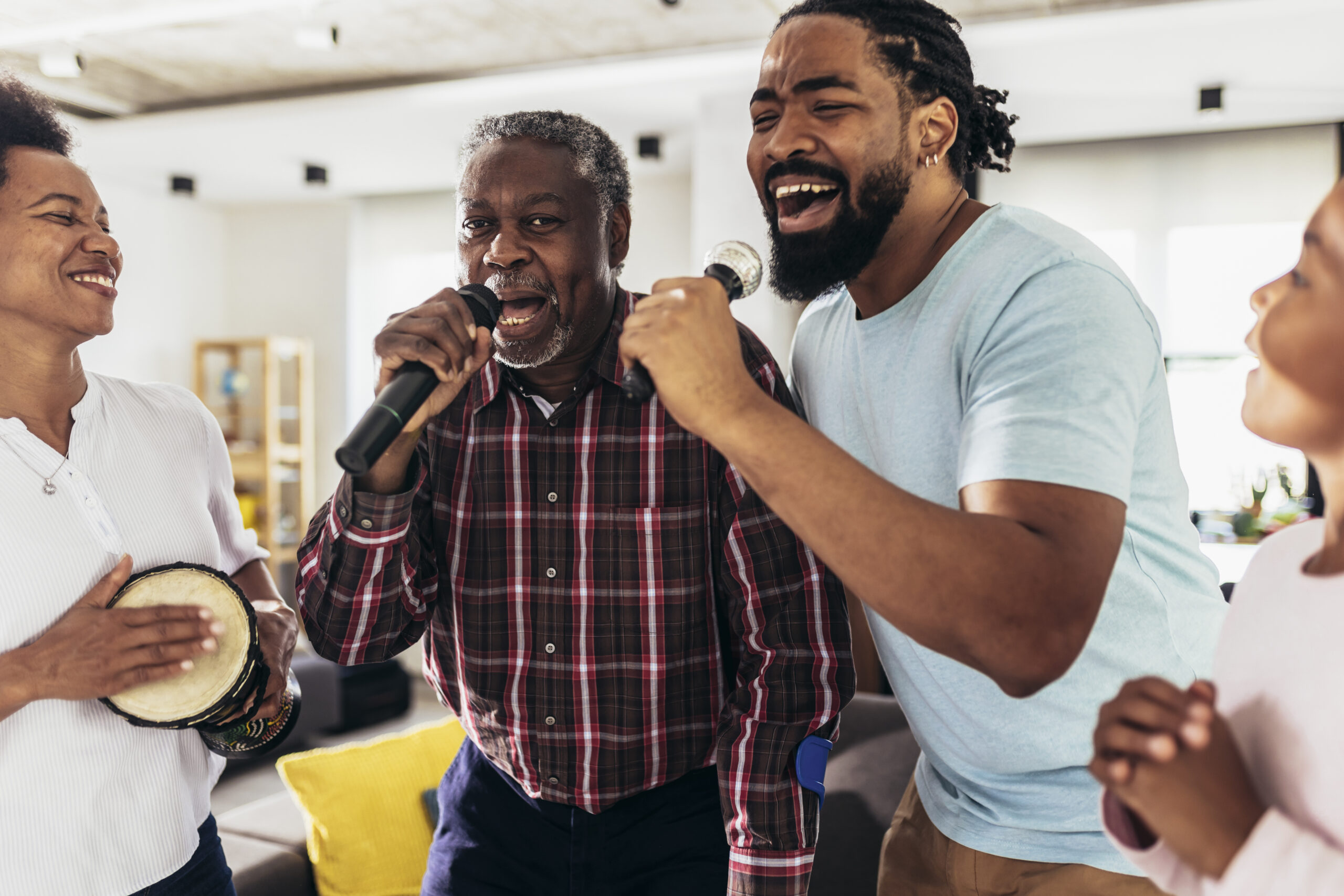 Family singing karaoke with microphones at home